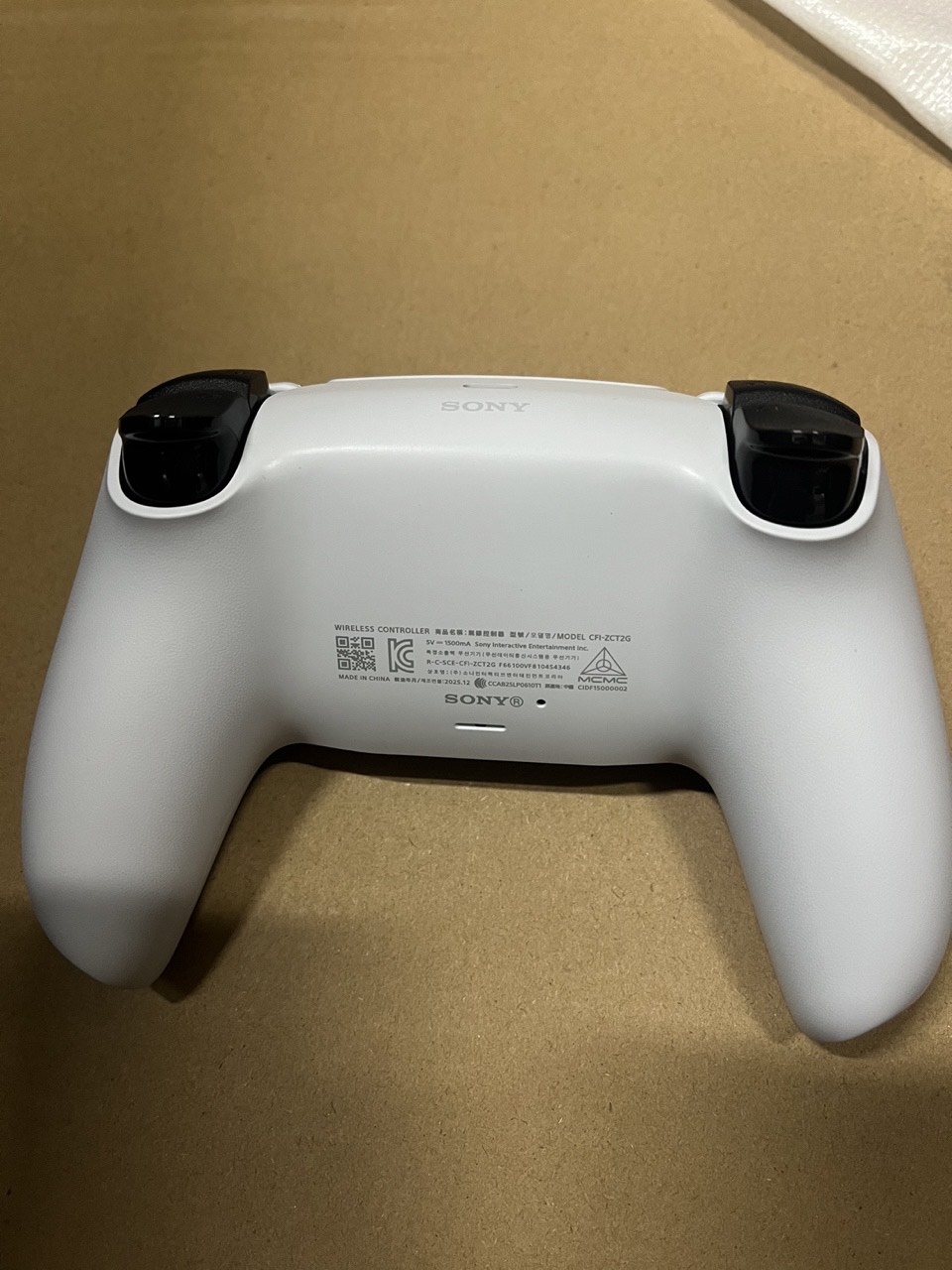 Back view of the white DualSense wireless controller and product label